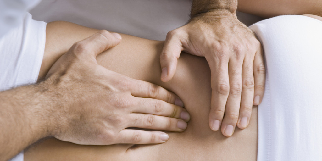 Chiropractor adjusting woman's spine